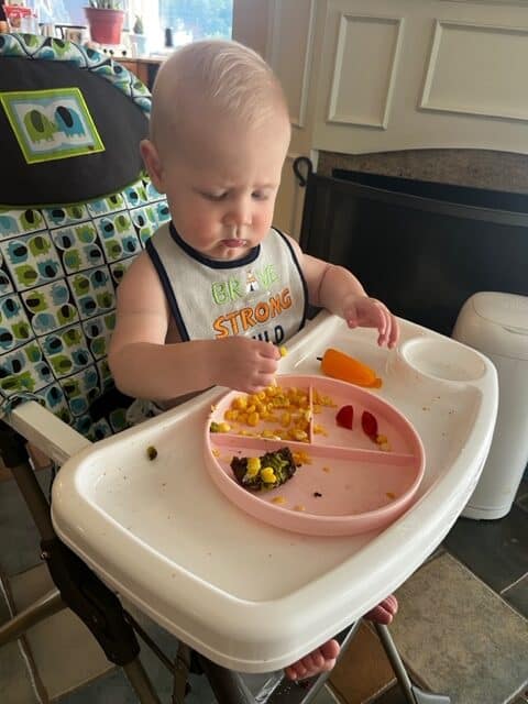 baby sitting in high chair at 9 months