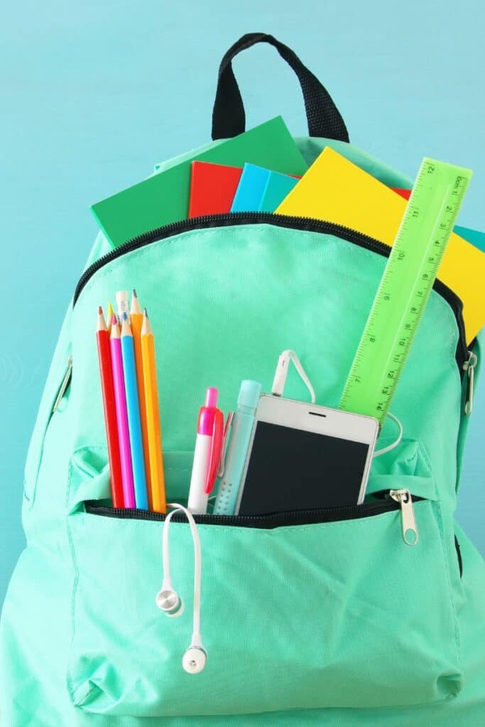 teal backpack with school supplies sticking out