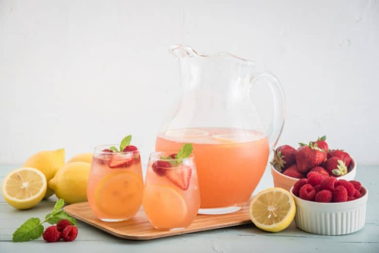 berry lemonade pitcher with two glasses of strawberry lemon lemonade