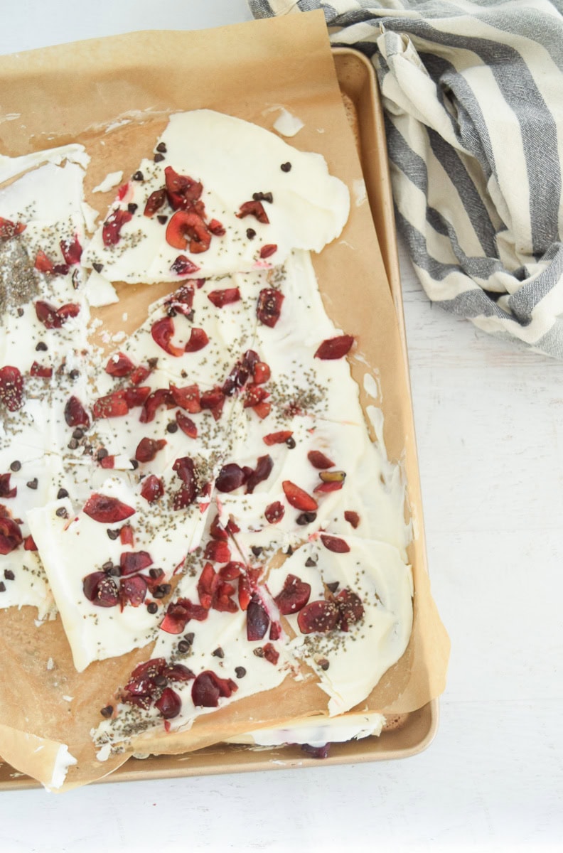 frozen greek yogurt bark on sheet pan with berries on top