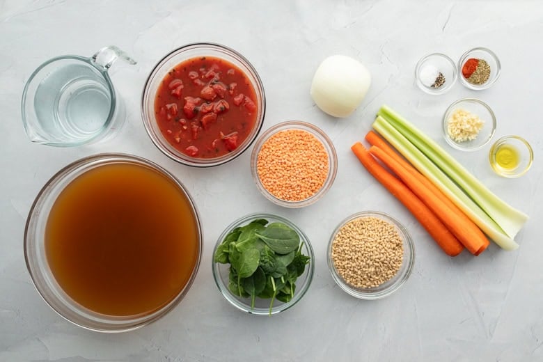 overhead view of broth, vegetables, lentils and barley to make vegetable soup with barley and vegetables