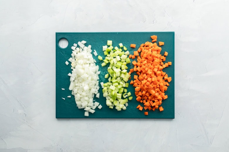 cutting board with diced carrots, onions and celery
