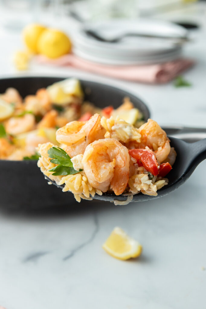 Delicious shrimp orzo pasta with feta cheese on fork, perfect for quick, flavorful meals. 
