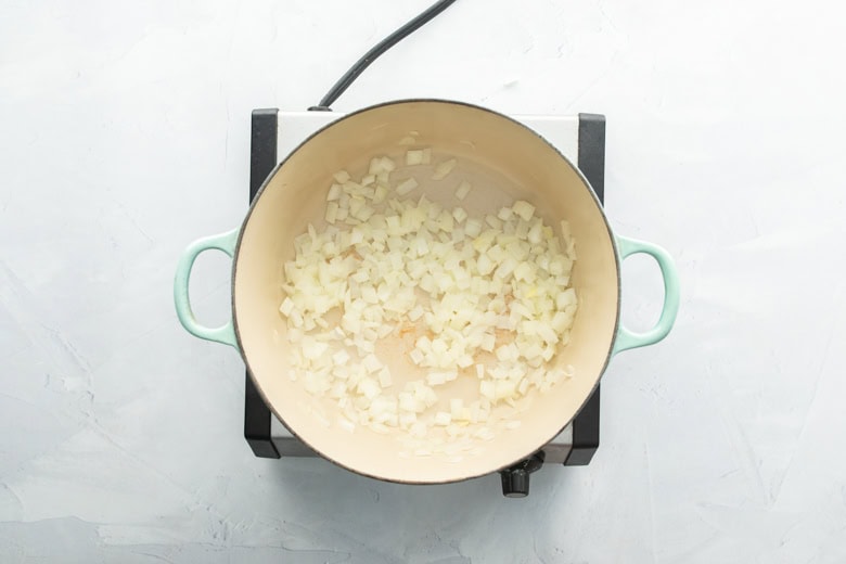 sauteeing onions in large cooking pan