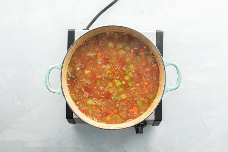 barley and vegetable soup cooking in pan