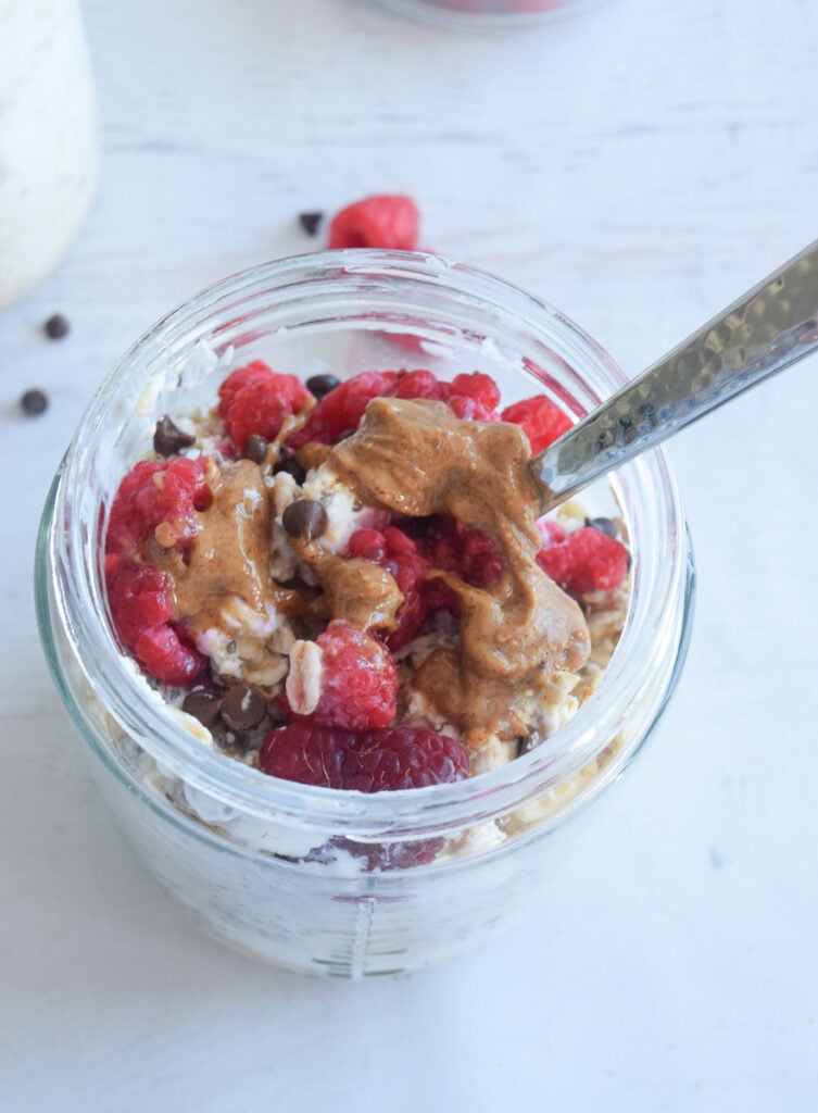 closeup of chocolate raspberry overnight oats with chocolate chips and almond butter