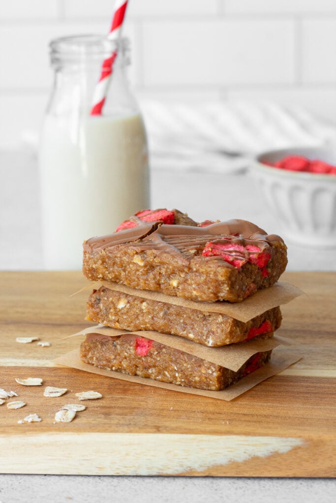 stacked oatmeal and date bars with milk in background