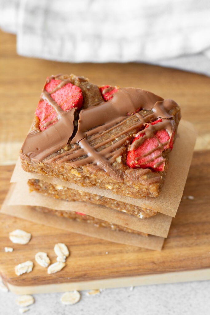 stacked date and oatmeal bars with drizzled chocolate and strawberries