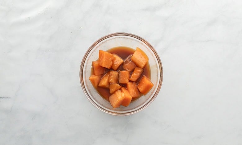 Salmon bites in clear bowl with marinade