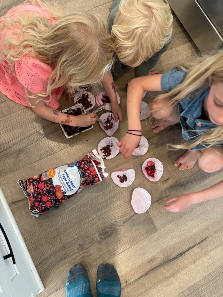 kids making dessert with frozen berries in the kitchen