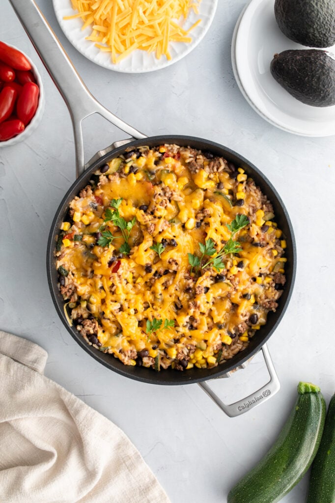 skillet with mexican rice and beef and melted cheese on top.