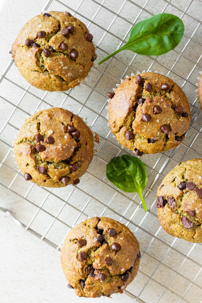 closeup of spinach banana muffins with chocolate chips on cooling tray 