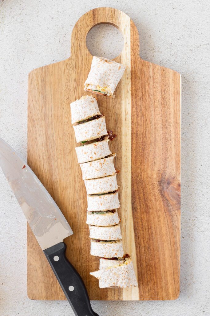 veggie pinwheels on wooden cutting board with knife