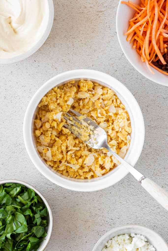 mashed chickpeas in a white bowl