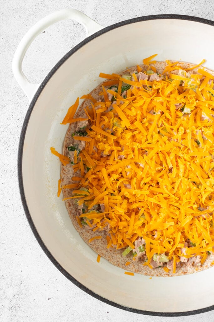 quesadilla topped with tuna melt and shredded cheese
