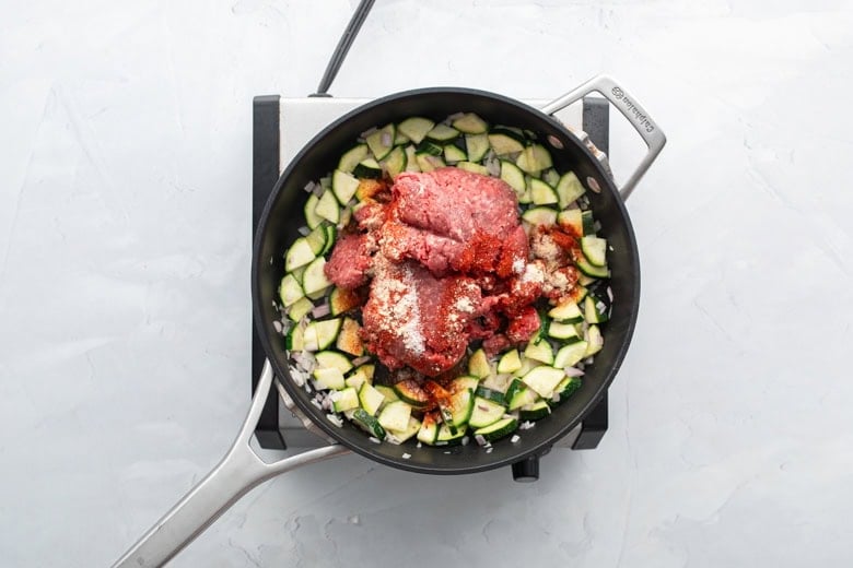 diced veggies and ground beef cooking over medium-high heat in skillet.