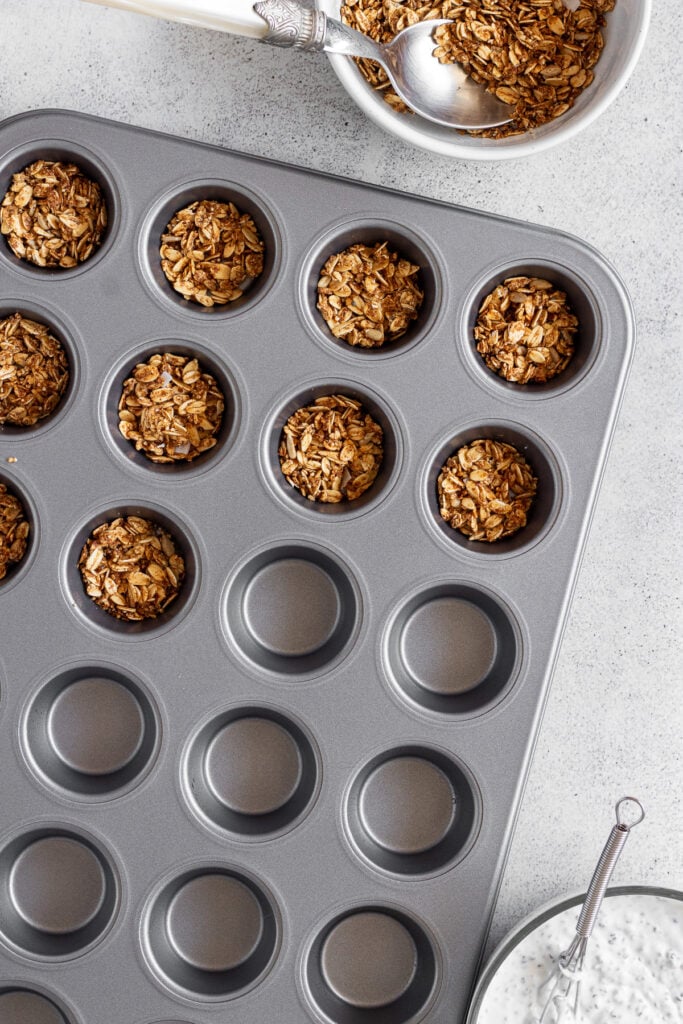 mini muffin tin with granola on the bottom for greek yogurt frozen bites