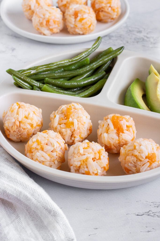 canned salmon bites with green beans and avocado on baby plate
