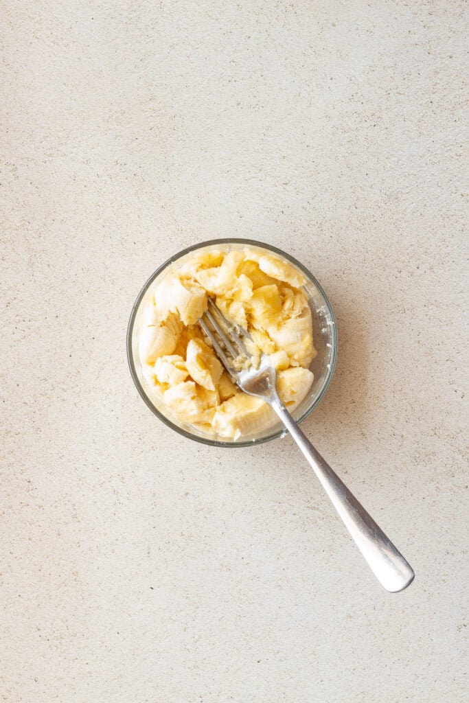 mashed bananas in clear bowl