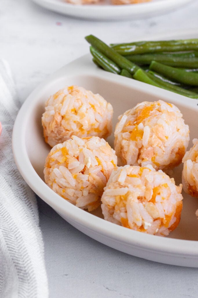 closeup of salmon rice balls on white plate
