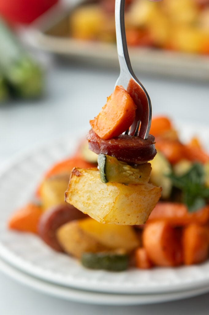 close up of potatoes, kielbasa and zucchini on fork