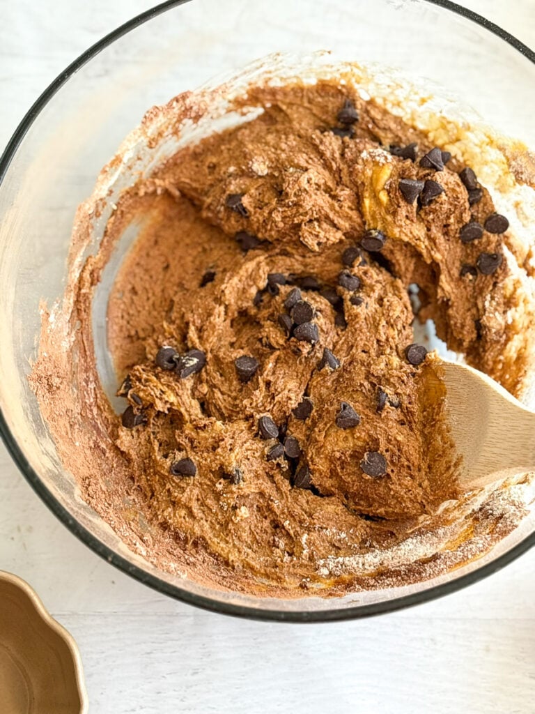 pumpkin chocolate brownie batter with chocolate chips in clear mixing bowl