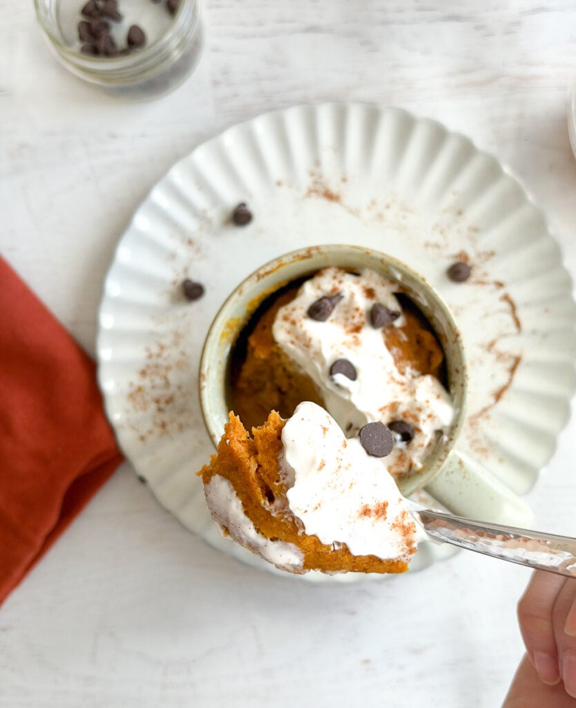 spoon with pumpkin mug cake close up over mug
